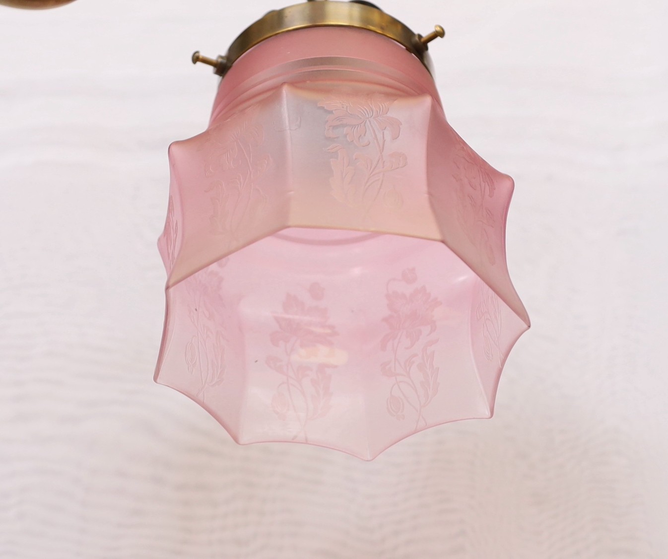 A late 19th century brass gasolier twin branch ceiling light with cranberry tinted etched glass shades, height 43cm. extends to 95cm